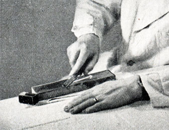 Рис. 46. Правильное положение оселка, бритвы и руки при точке на смоченном водой камне. Впереди виден маленький камень для сланцевого порошка