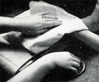 Рис. 393. Вытирание, смягченной в теплой ванне, левой руки. Впереди мы видим правую руку в смягчающей кожу ванне
